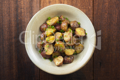 Oven roasted potatoes on wooden table top view