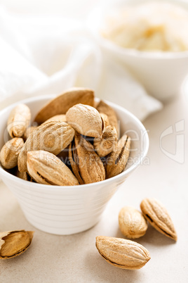 Almond nuts in a bowl on white background, healthy eating