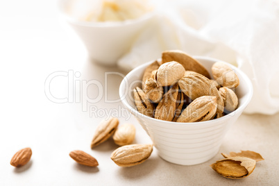 Almond nuts in a bowl on white background, healthy eating