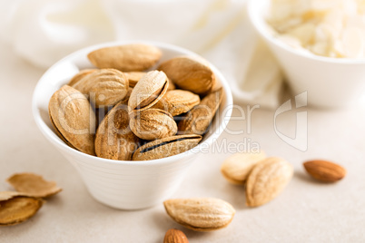 Almond nuts in a bowl on white background, healthy eating