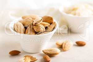 Almond nuts in a bowl on white background, healthy eating