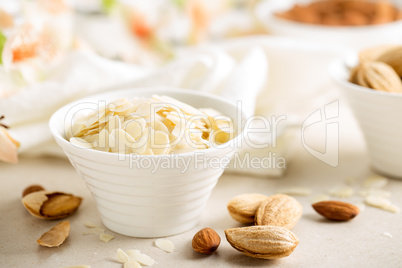 Almond nuts shavings in a bowl on white background, healthy eating