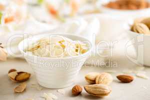 Almond nuts shavings in a bowl on white background, healthy eating