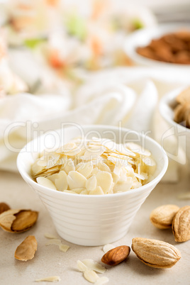Almond nuts shavings in a bowl on white background, healthy eating