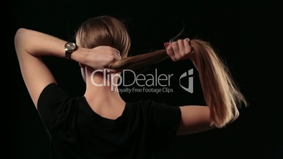 Woman holding long hair and pulling blond hair