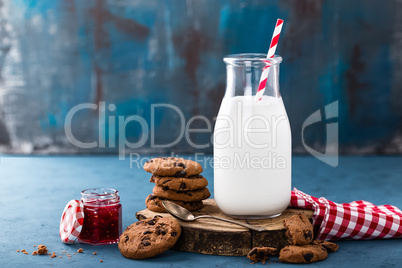 Milk in glass bottle on blue background, breakfast