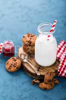 Milk in glass bottle on blue background, breakfast