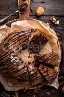 Chocolate brownie cake, dessert with nuts on dark background, top view