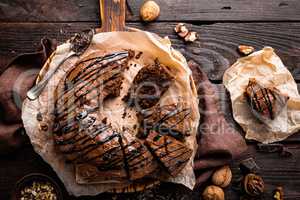 Chocolate brownie cake, dessert with nuts on dark background, top view