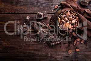 Cocoa beans and chocolate on wooden background