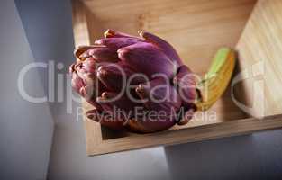 Fresh Artichoke in a square wooden plate.