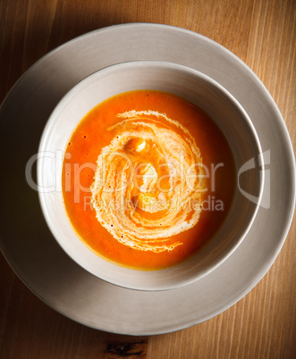Pumpkin soup with cream served on a table