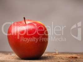 Red organic apple on wood
