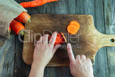 process of slicing carrots on slices on a kitchen board