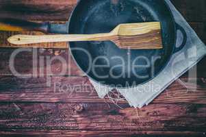 Empty frying pan on a brown wooden surface