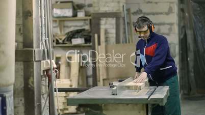 Skilled carpenter cutting wood using circular saw