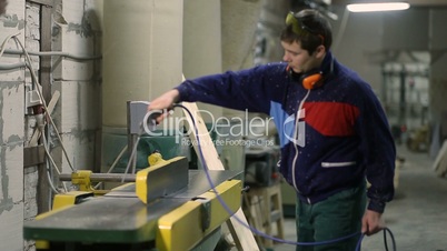 Carpenter using air nozzles gun to clean workplace