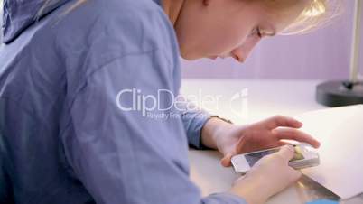 Teen Girl make homework using a smartphone