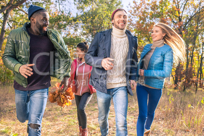 Happy friends walking in autumn park