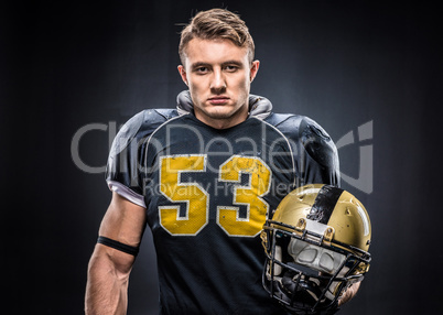 American football player holding helmet