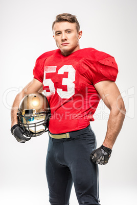 Football player holding helmet