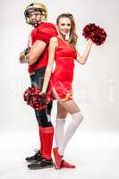 Football player standing with cheerleader