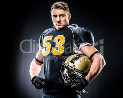 American football player holding helmet