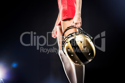 Female football player holding helmet