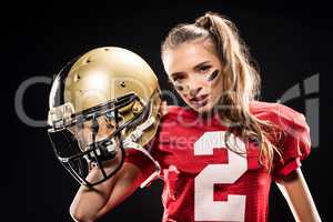 Female football player posing with helmet