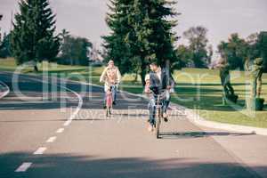 Happy family riding bicycles in park