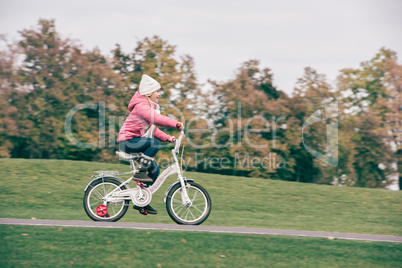 Little girl riding bicycle in park
