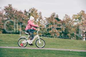 Little girl riding bicycle in park