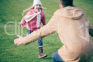 Adorable smiling girl running to father
