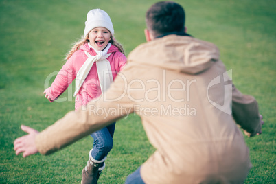 Adorable smiling girl running to father