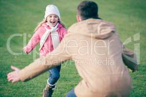 Adorable smiling girl running to father