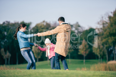 Happy family holding hands on meadow