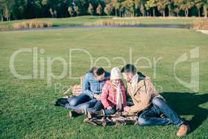 Beautiful family sitting on green meadow