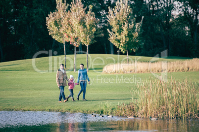 Happy family walking near lake