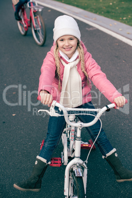 Adorable smiling girl sitting on bicycle