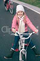 Adorable smiling girl sitting on bicycle