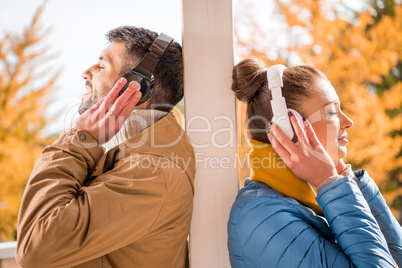 Young man and woman standing in headphones