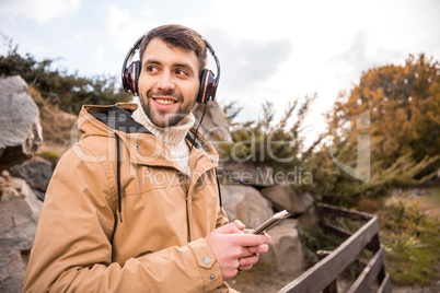 Man in headphones holding smartphone