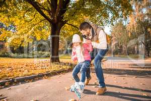 Father teaching daughter to roller skating