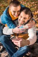 Beautiful smiling couple looking at smartphone