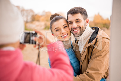 Girl photographing beautiful smiling couple