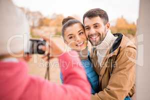 Girl photographing beautiful smiling couple