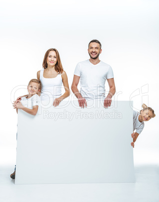 Happy family holding blank card