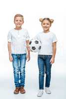 Smiling children standing with soccer ball