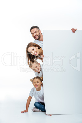 Smiling family holding blank card