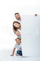 Smiling family holding blank card